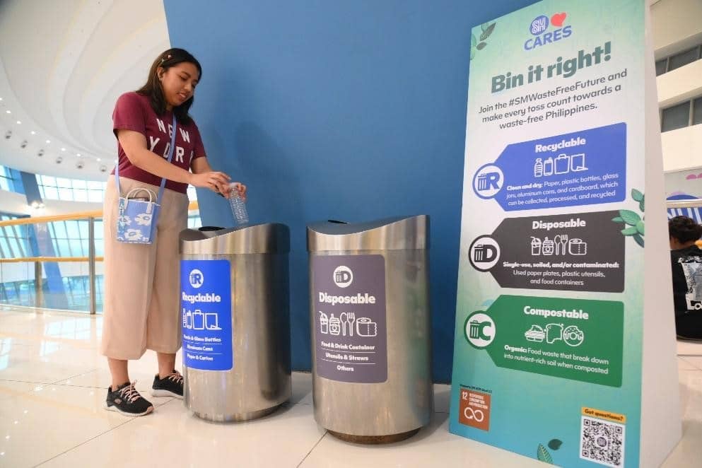 Bin it right! Mallgoer throwing her plastic water bottle in the recyclable bin.